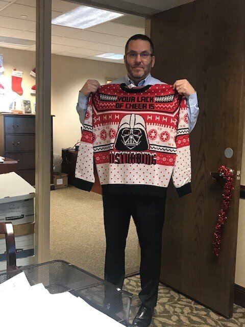 Tom, who could not be here to wear his sweater because he had to attend a meeting.